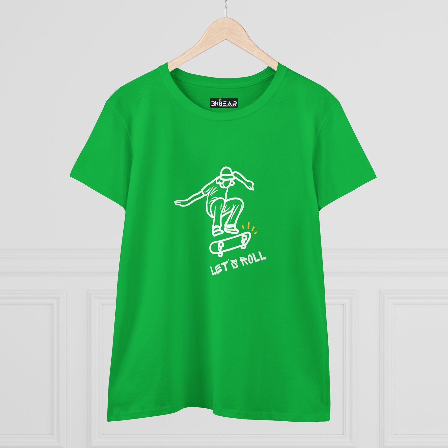 Green Let’s Roll shirt with white skateboarder graphic and text hanging on wooden hanger