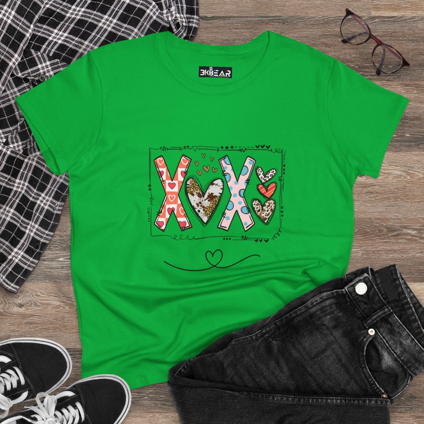 Green sign of love shirt with colorful XOX heart design laid flat with black jeans and accessories