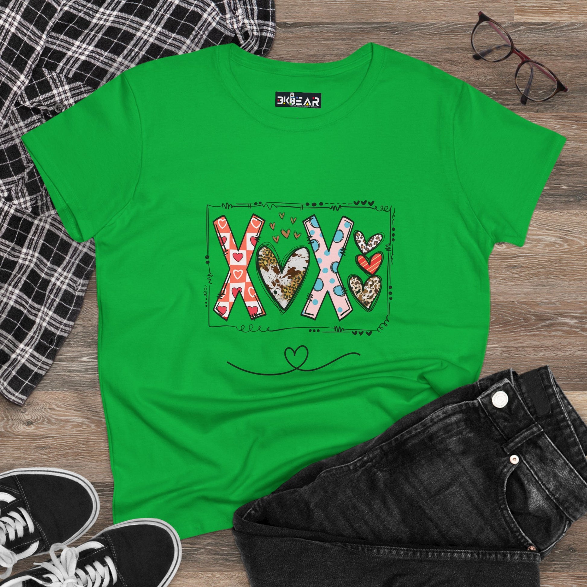 Green sign of love shirt with colorful XOX heart design laid flat with black jeans and accessories
