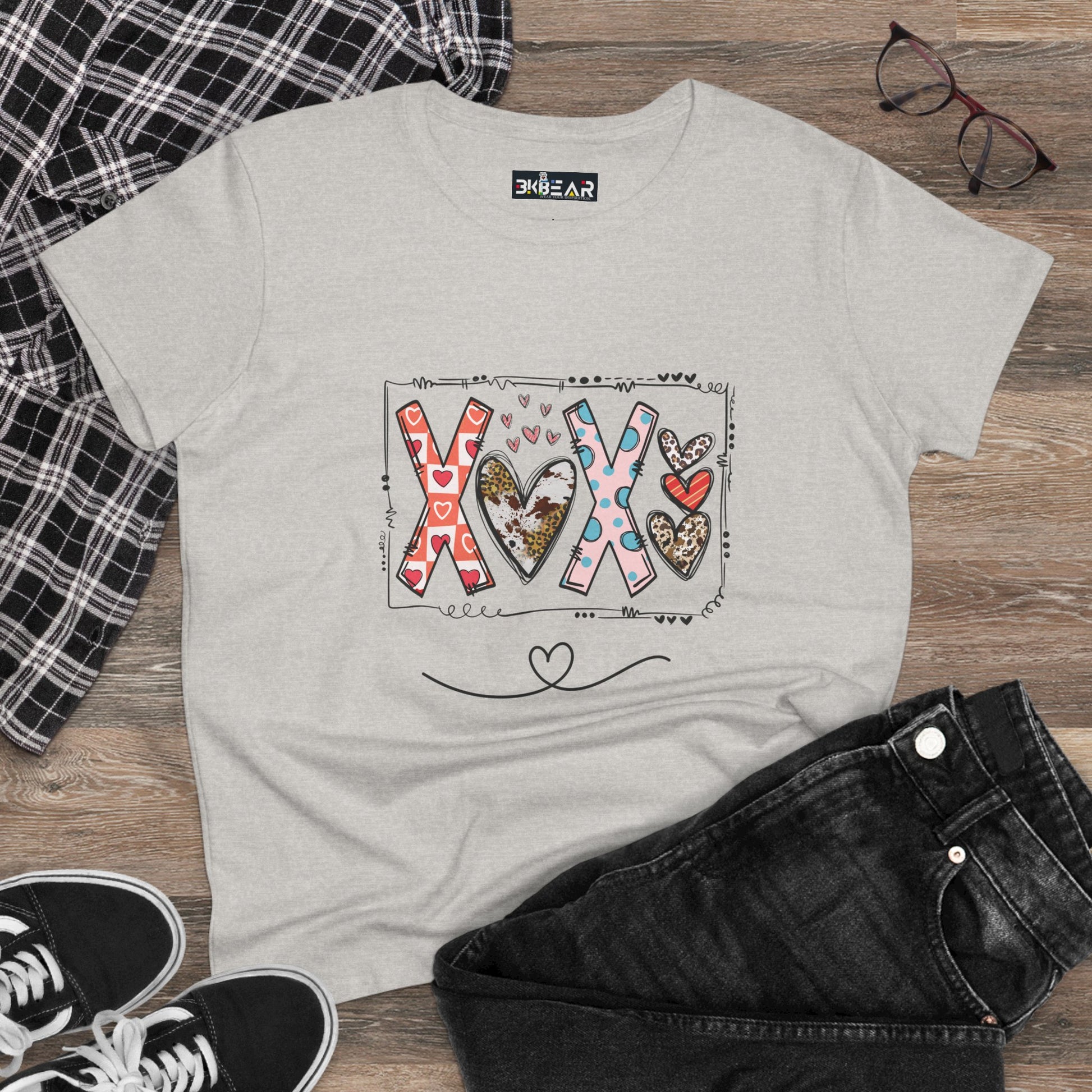 Light gray sign of love shirt with colorful heart and XOX design laid out with black jeans and sneakers