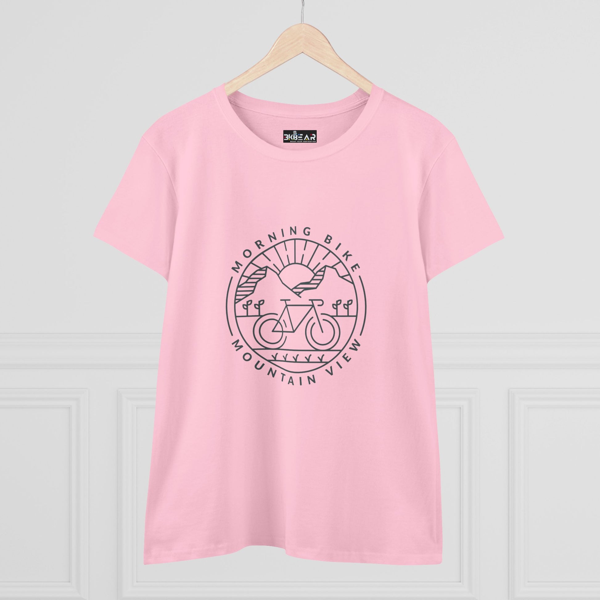 Pink Printify morning bike t-shirt with mountain view graphic on front on a hanger