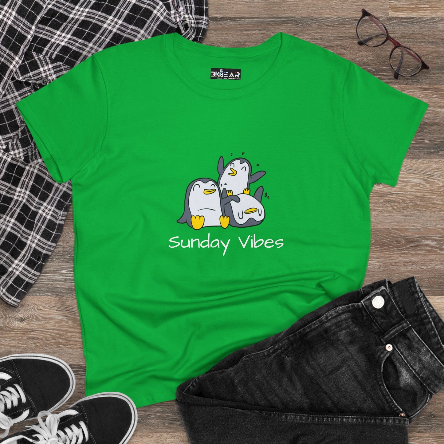 Green Printify sunday vibes graphic tee with playful penguin design laid flat with casual outfit
