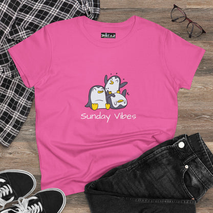Pink sunday vibes graphic tee with cute penguin design laid flat with black jeans and plaid shirt