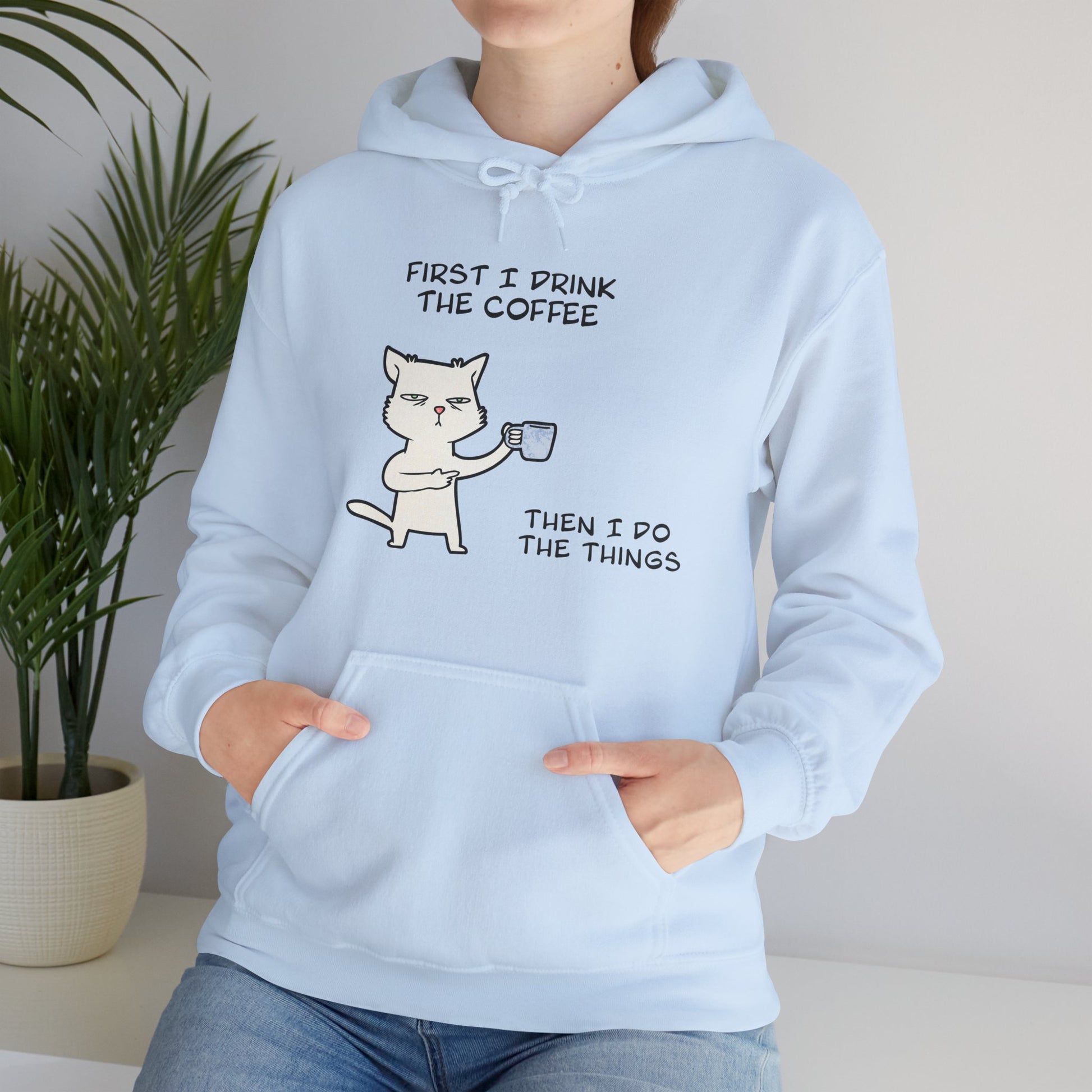Printify but first coffee hoodie in light blue with a cat holding a coffee cup graphic