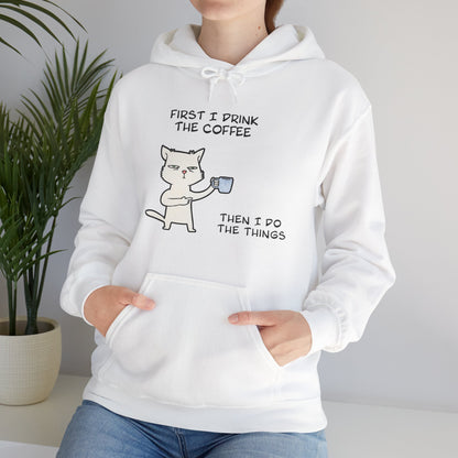 White but first coffee hoodie from Printify featuring a cat holding a coffee cup and text design