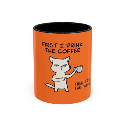 Orange coffee mug with black interior featuring a cat holding a cup and text coffee mugs