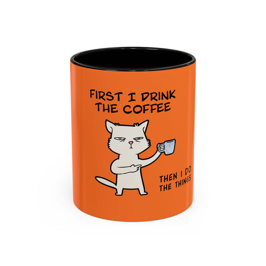 Orange coffee mug with black interior featuring a cat holding a cup and text coffee mugs
