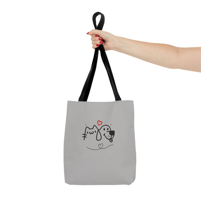 Printify cute dog lover tote bag with cartoon dog and cat design held by hand with black straps