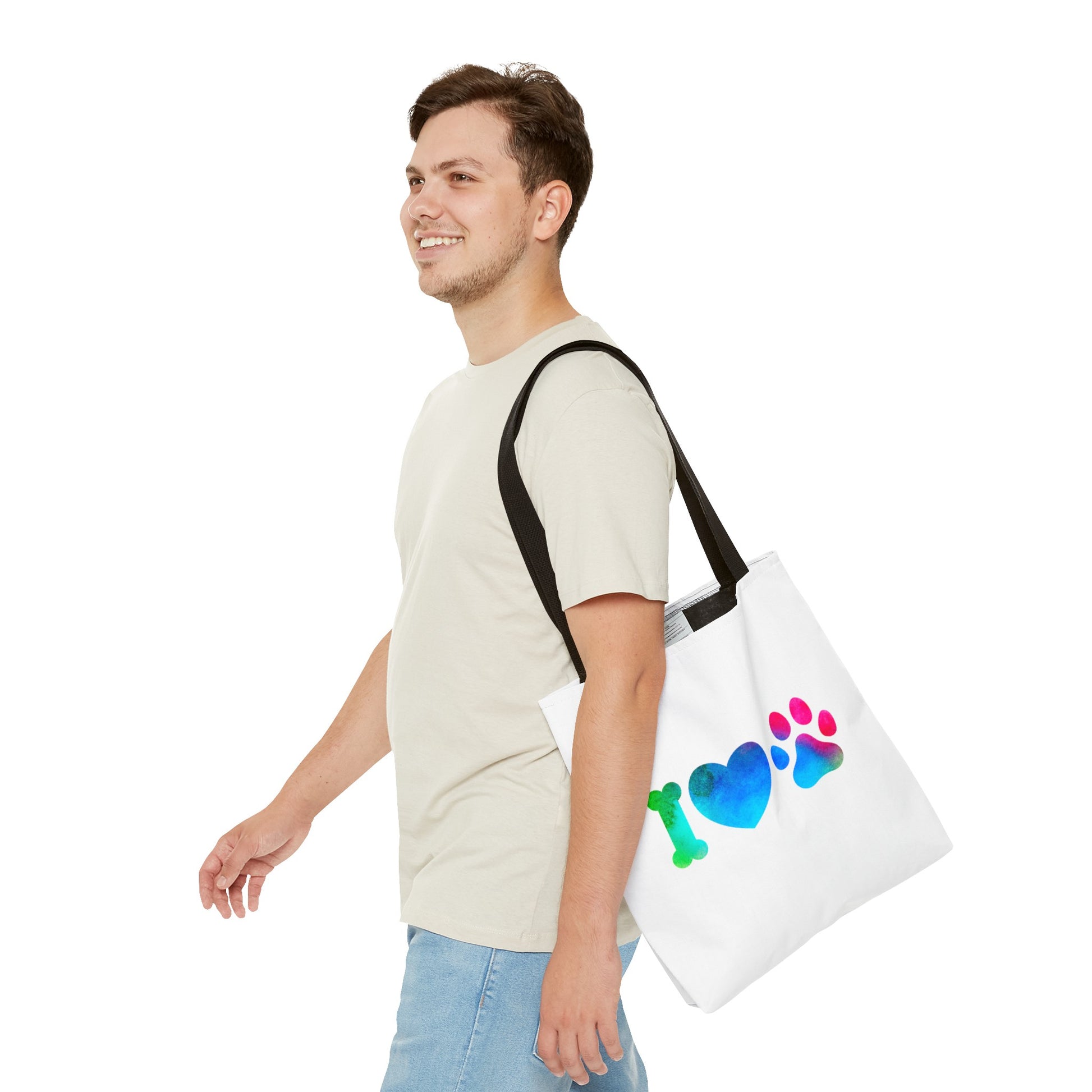 Man carrying a white cute dog lover tote bag with colorful bone, heart, and paw print design