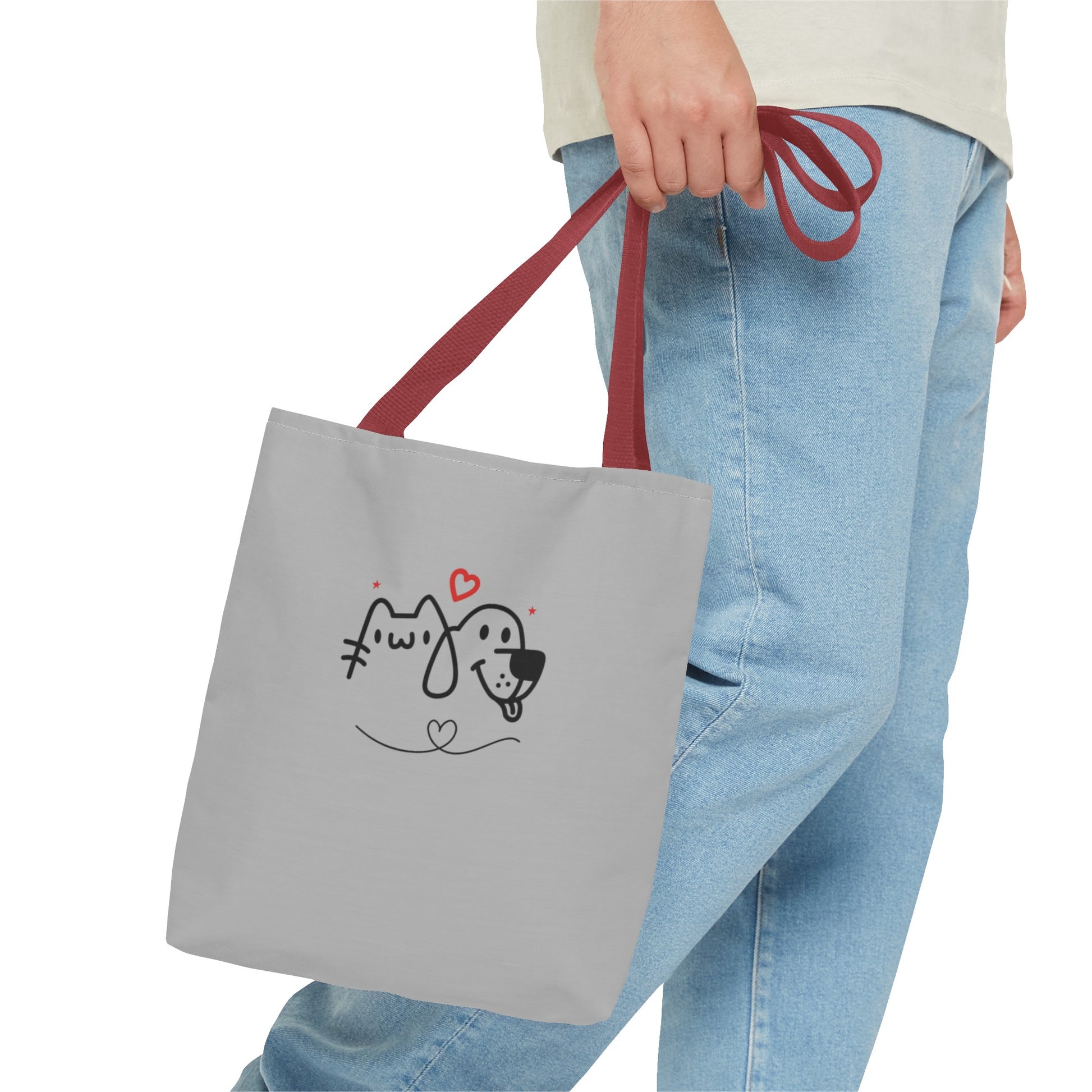 Hand holding gray cute puppy tote bag with red handles and a simple dog and cat face design