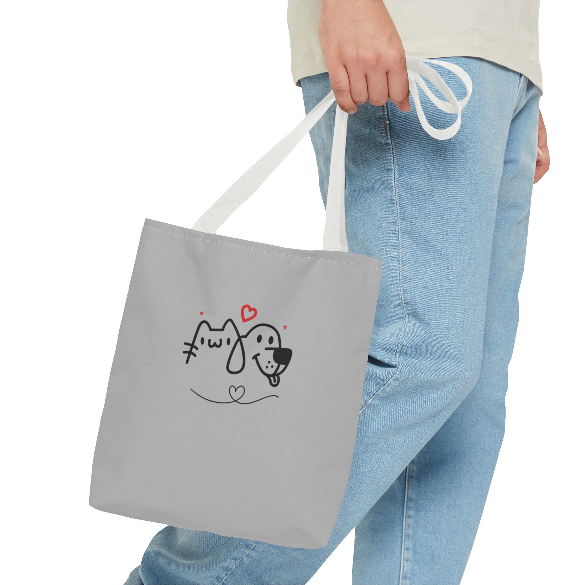 Person holding a gray cute puppy tote bag with a simple black and red puppy and cat design
