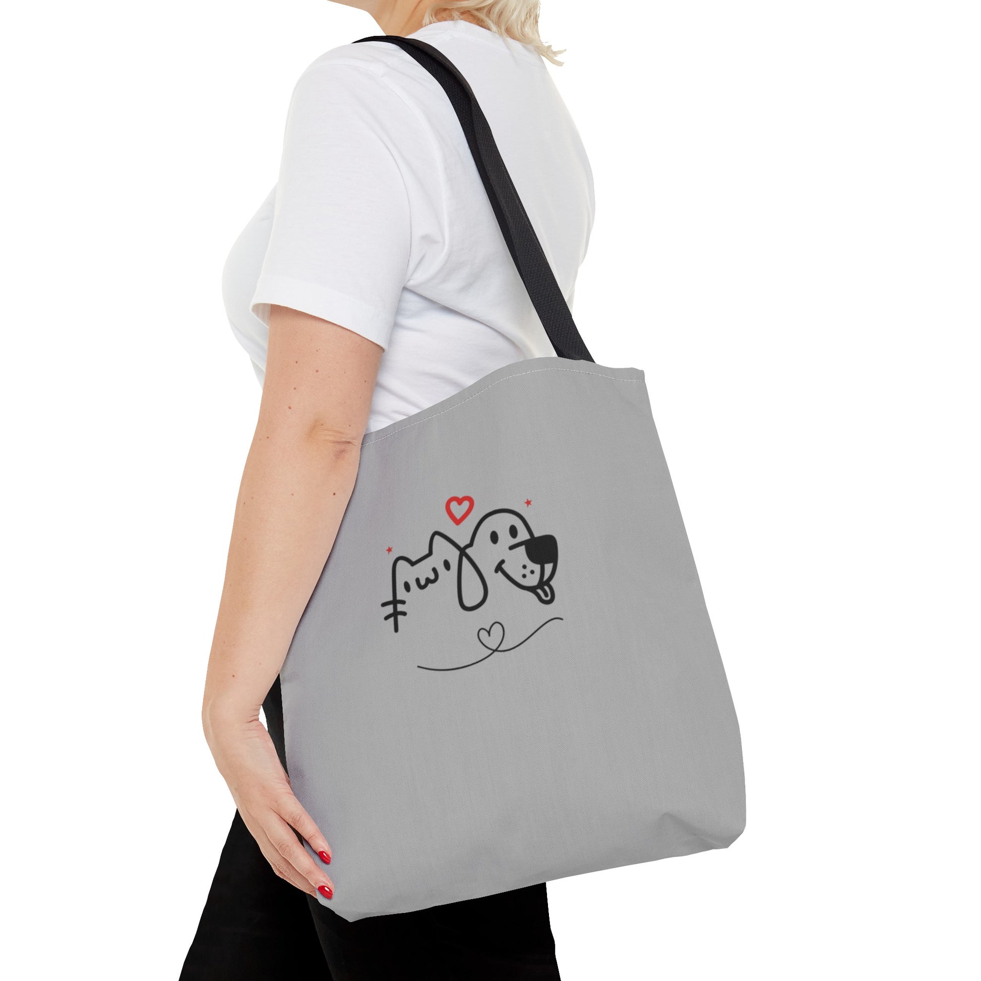 Woman carrying grey cute puppy tote bag with black handles and simple cartoon dog and cat design
