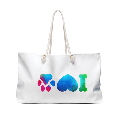 White dog lover weekender bag with colorful paw, heart, and bone designs and rope handles