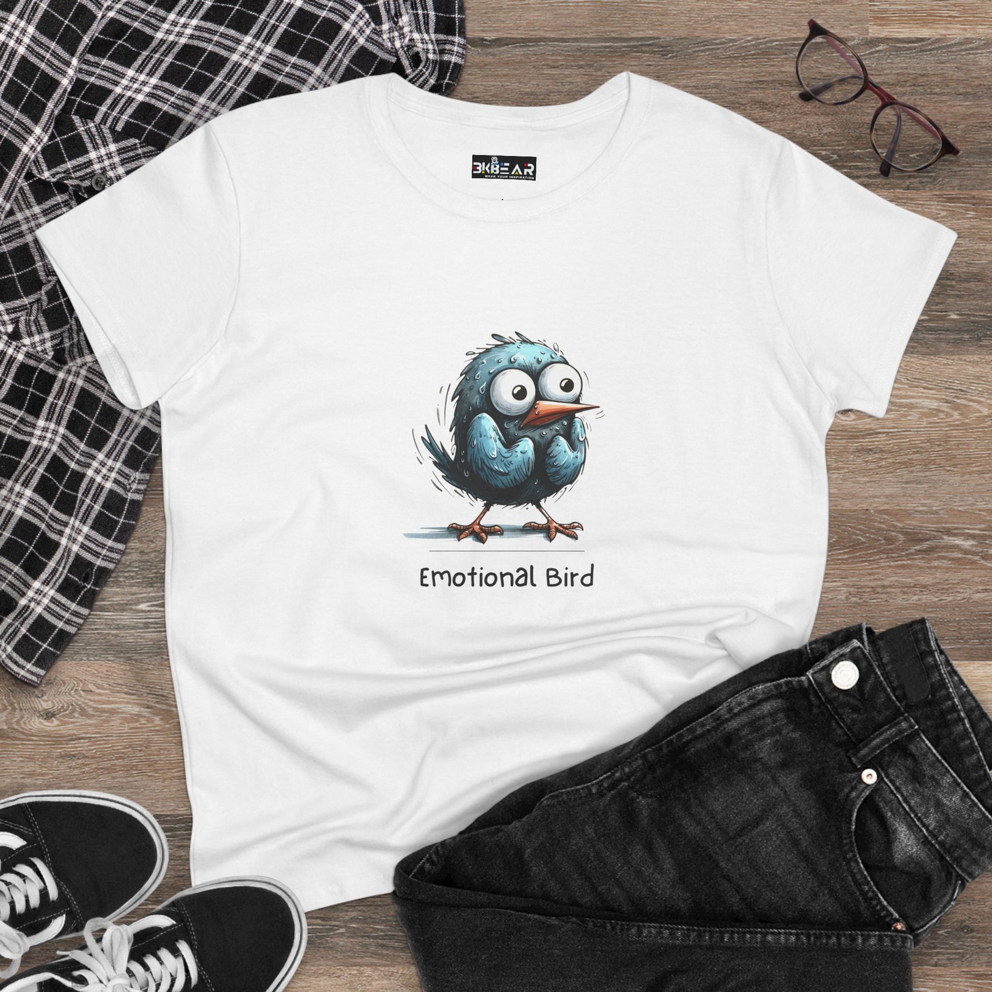 White emotional bird tee featuring a cartoon blue bird with big eyes on a wooden background