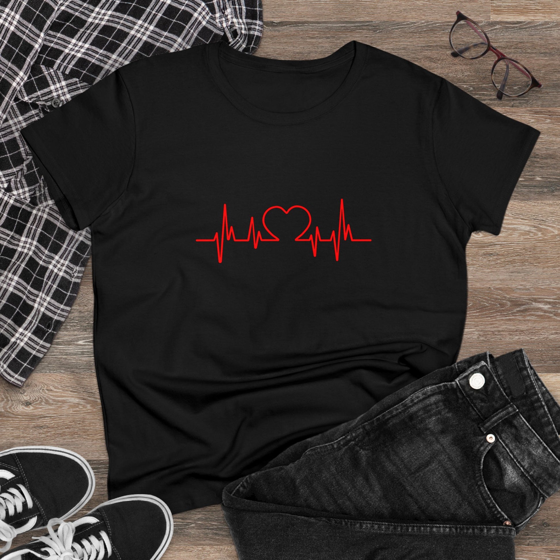 Black heartbeat graphic t-shirt with red heart and pulse line design laid flat with jeans and sneakers