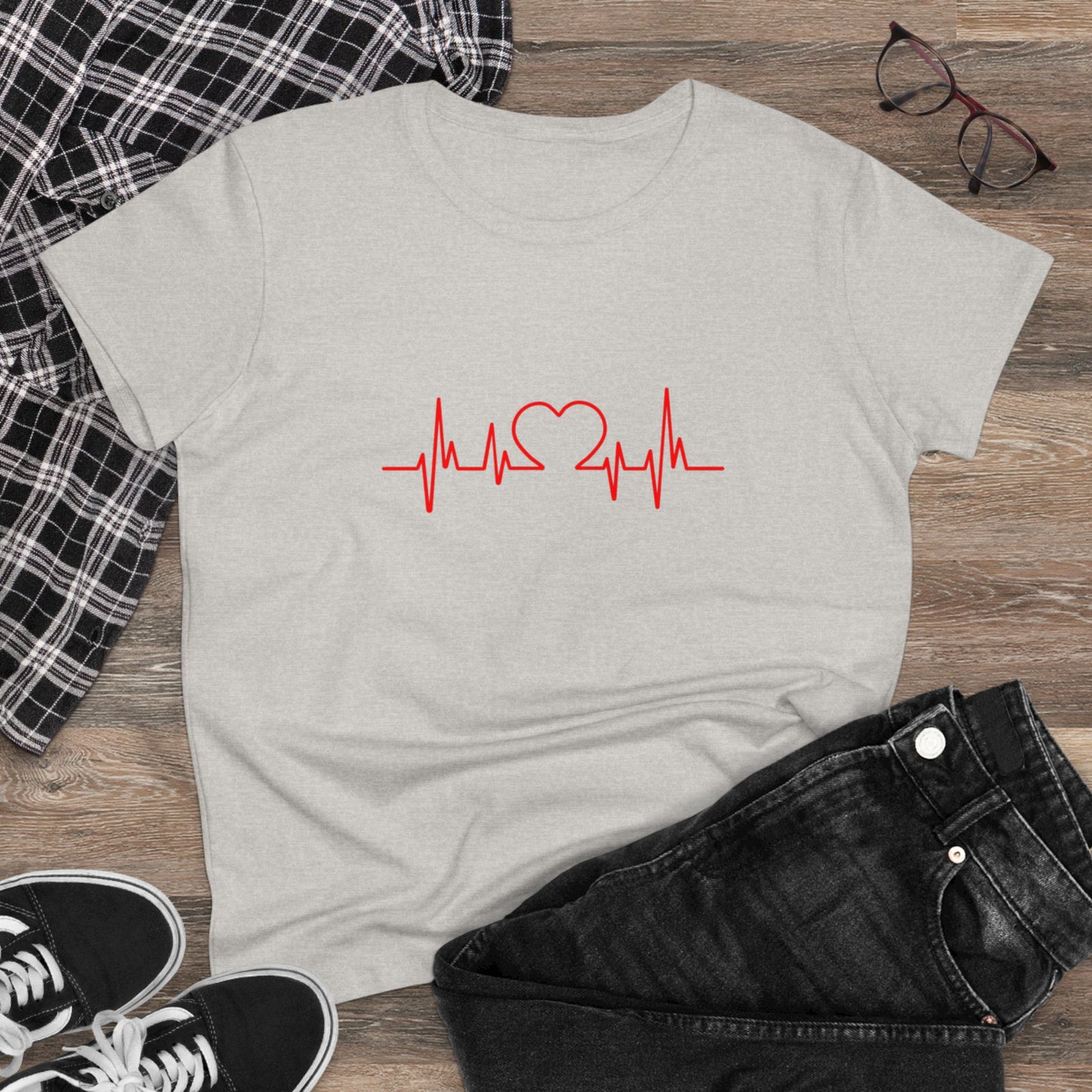 Gray Printify heartbeat graphic t-shirt with red heart and pulse design laid on wooden surface