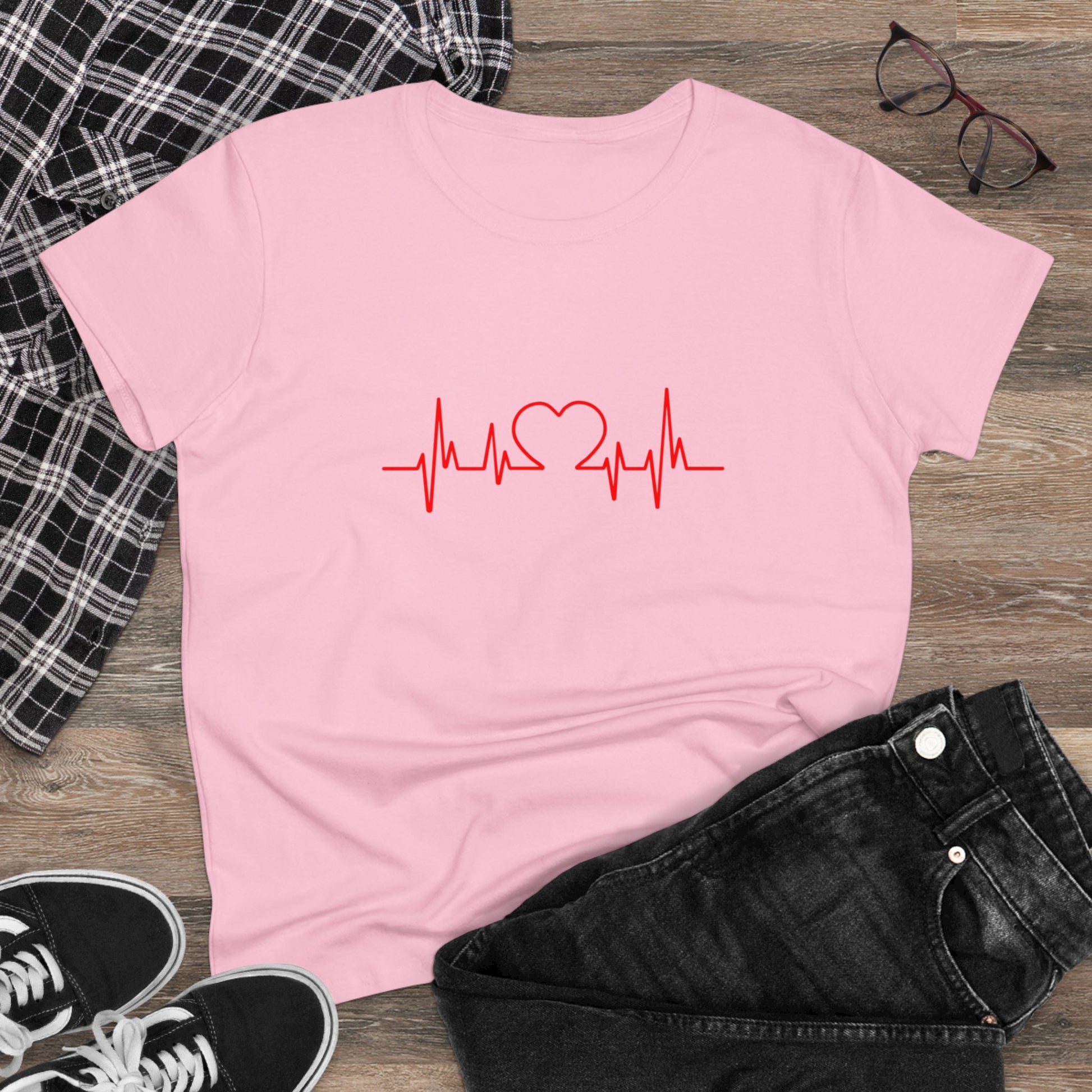 Pink heartbeat graphic t-shirt with red heart and pulse design laid flat with black jeans and shoes