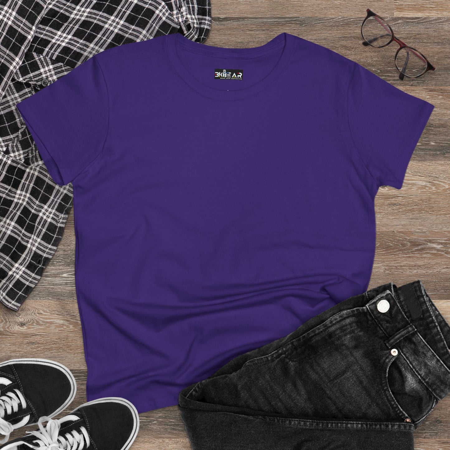 Purple heliconia t-shirt women laid on wooden floor with black jeans black sneakers and glasses