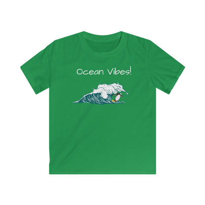 Green kids ocean vibes t-shirt by Printify with surfing penguin graphic and ocean waves
