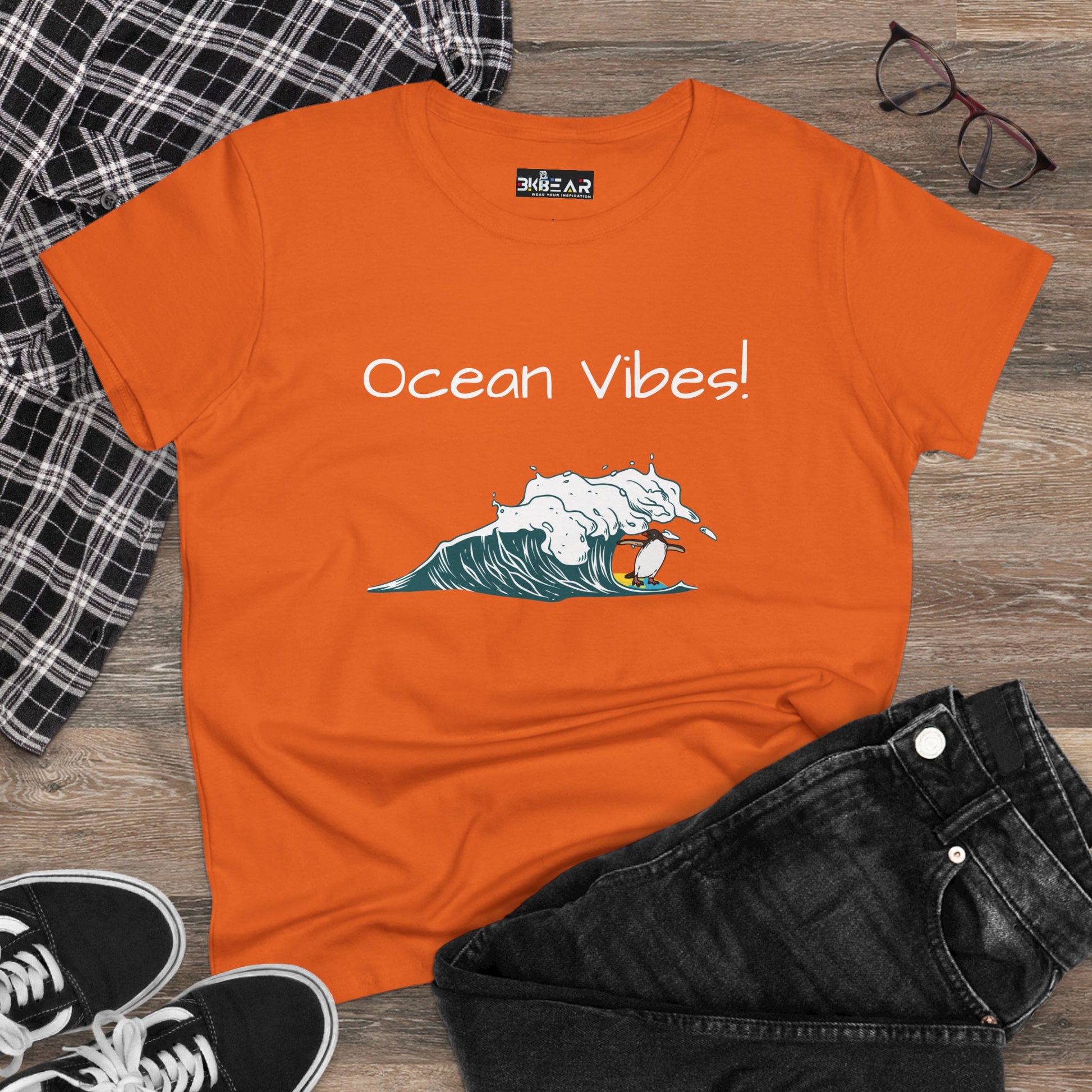Orange beach graphic tee with ocean vibes text and wave surfer design by Printify