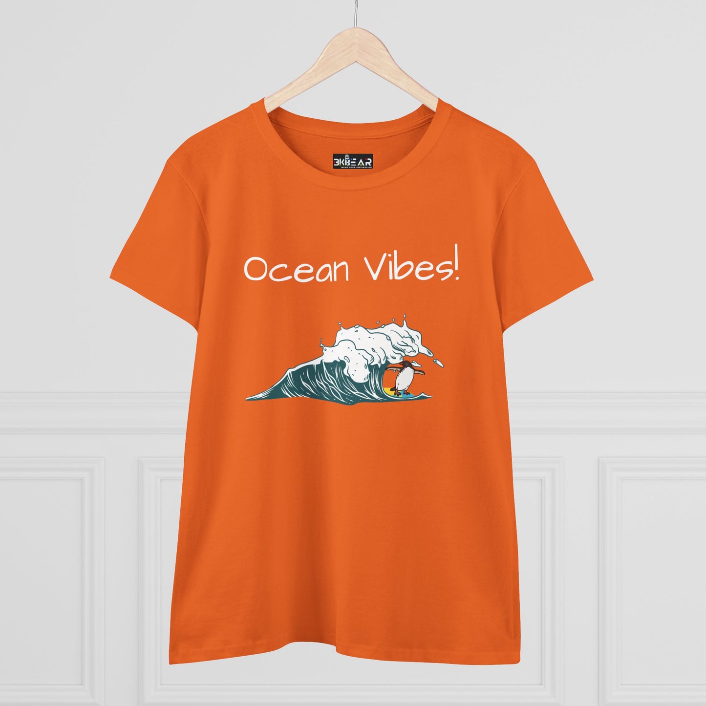 Orange beach graphic tee with ocean wave illustration and Ocean Vibes text by Printify