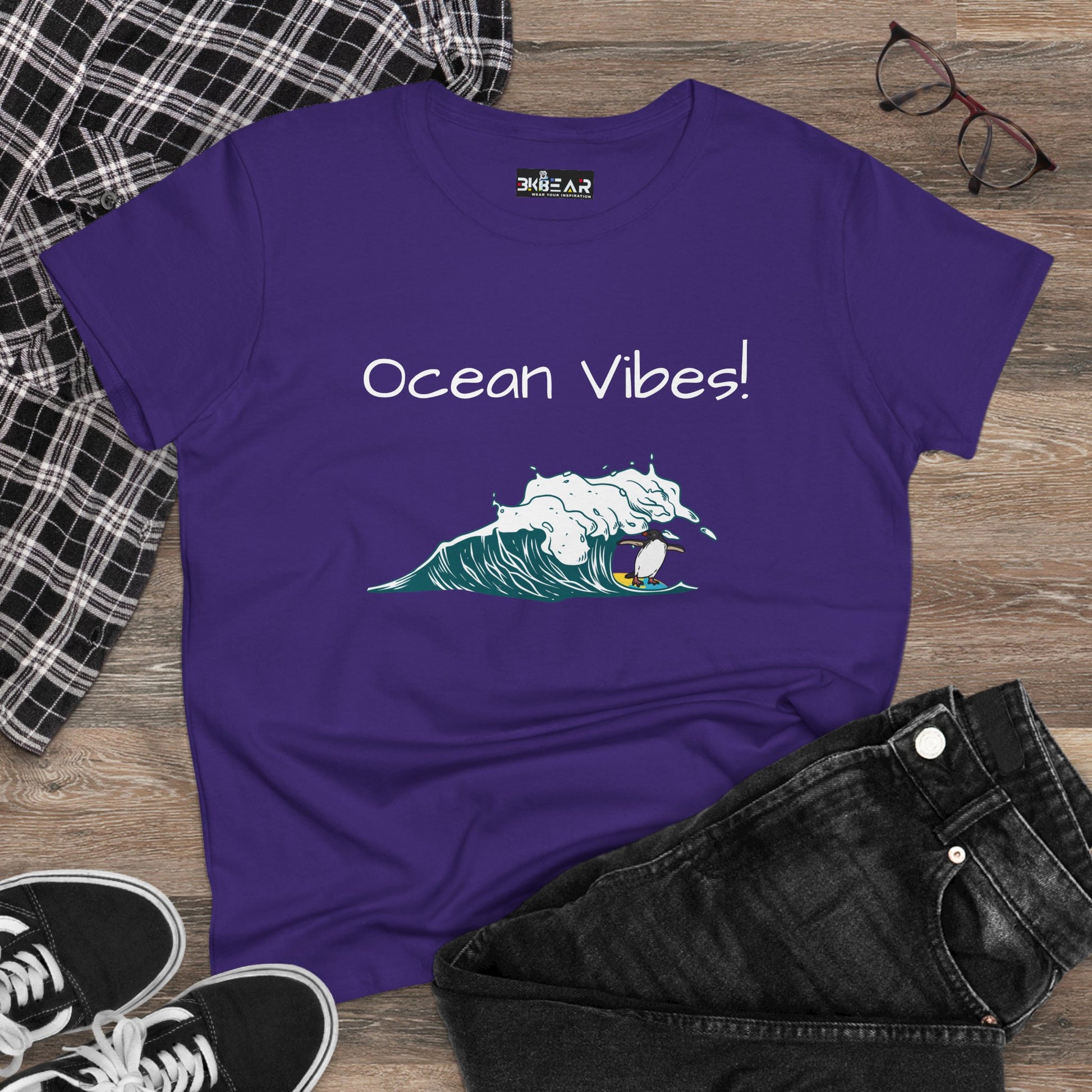 Purple Printify beach graphic tee with Ocean Vibes text and wave surfer design laid with black jeans and sneakers