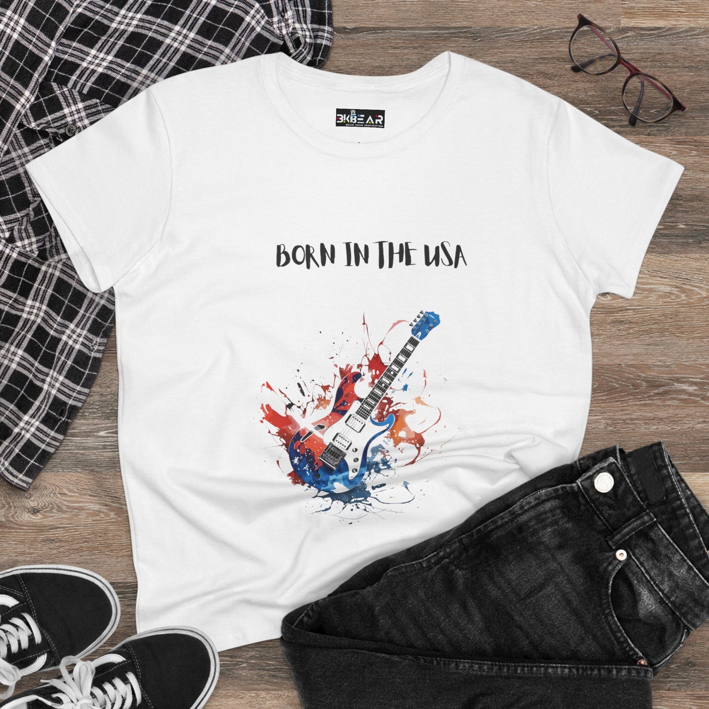 White patriotic guitar tee with Born in the USA text and guitar graphic on wooden background