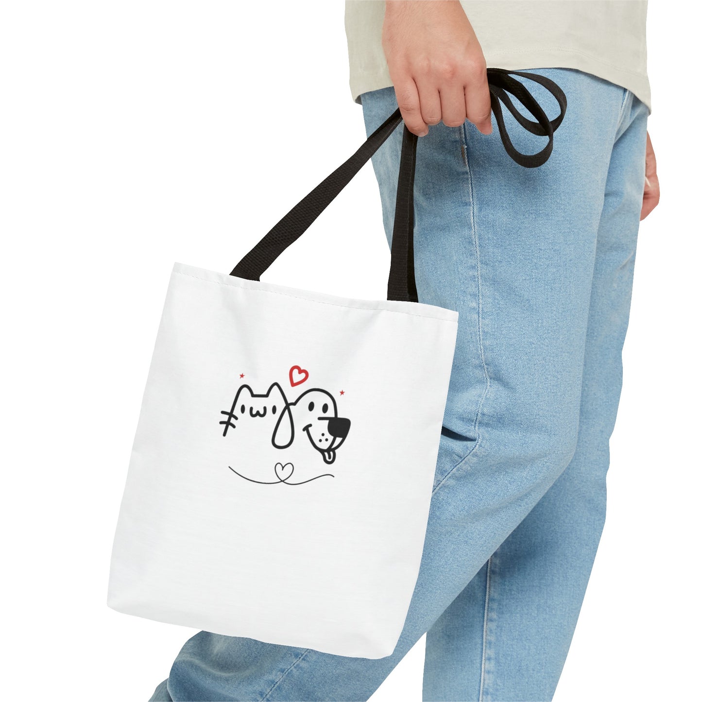 Person holding a white puppy love graphic tote bag with black handles and cute dog and cat design